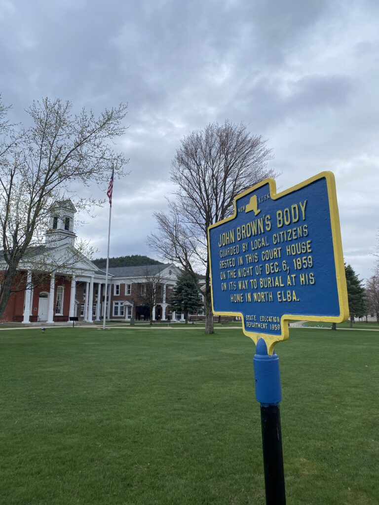 Essex County Courthouse with historic marker in foreground describing a night when Abolitionist John Brown's body was stored in the courthouse.